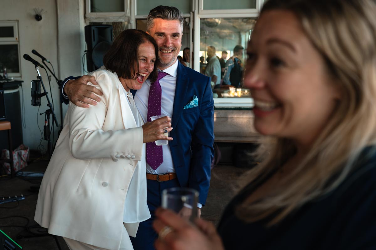 Same sex wedding photography. Guests laughing