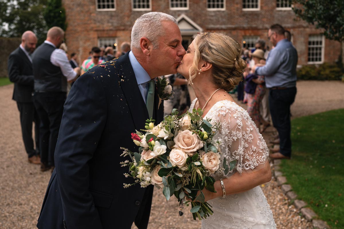 lara and phil share a kiss on their wedding day at westenhanger castle in kent