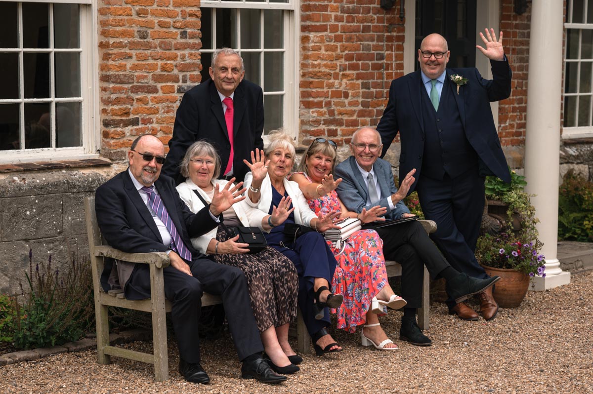 wedding guests pictured on bench outside westenhanger castle in kent