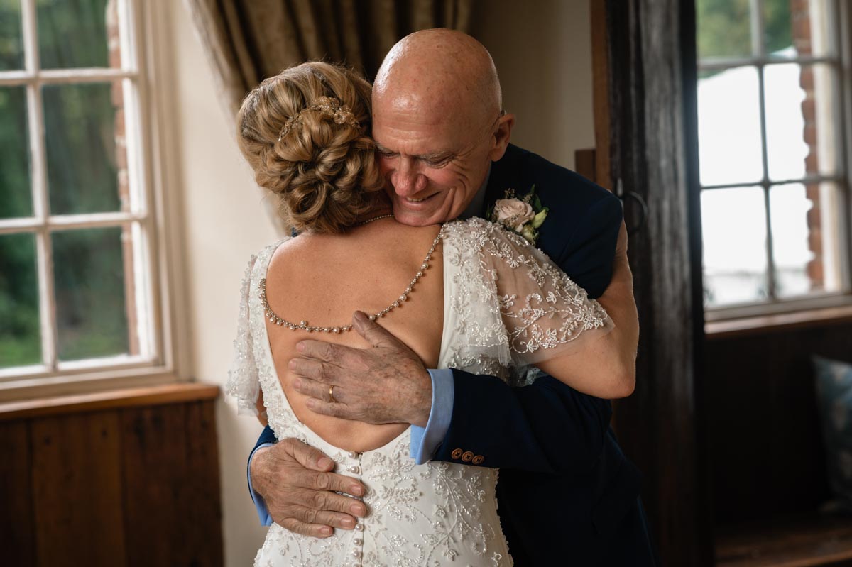 Bride and father hug before wedding at westenhanger castle in Kent