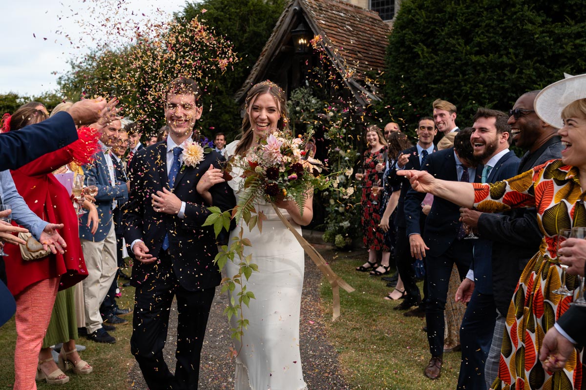 Poppy and Pablo photographed during their confetti throw at Bilsington Priory wedding
