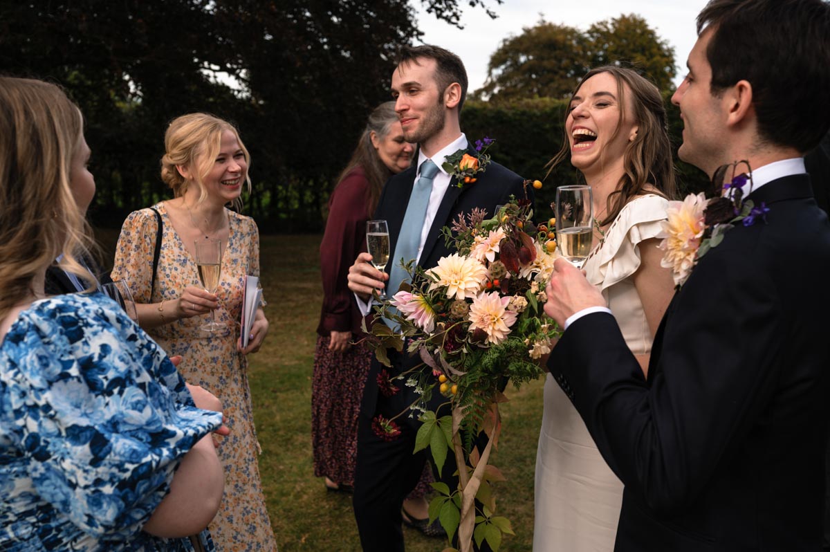 Natural wedding photography. Poppy and Pablo enjoy their wedding reception with friends