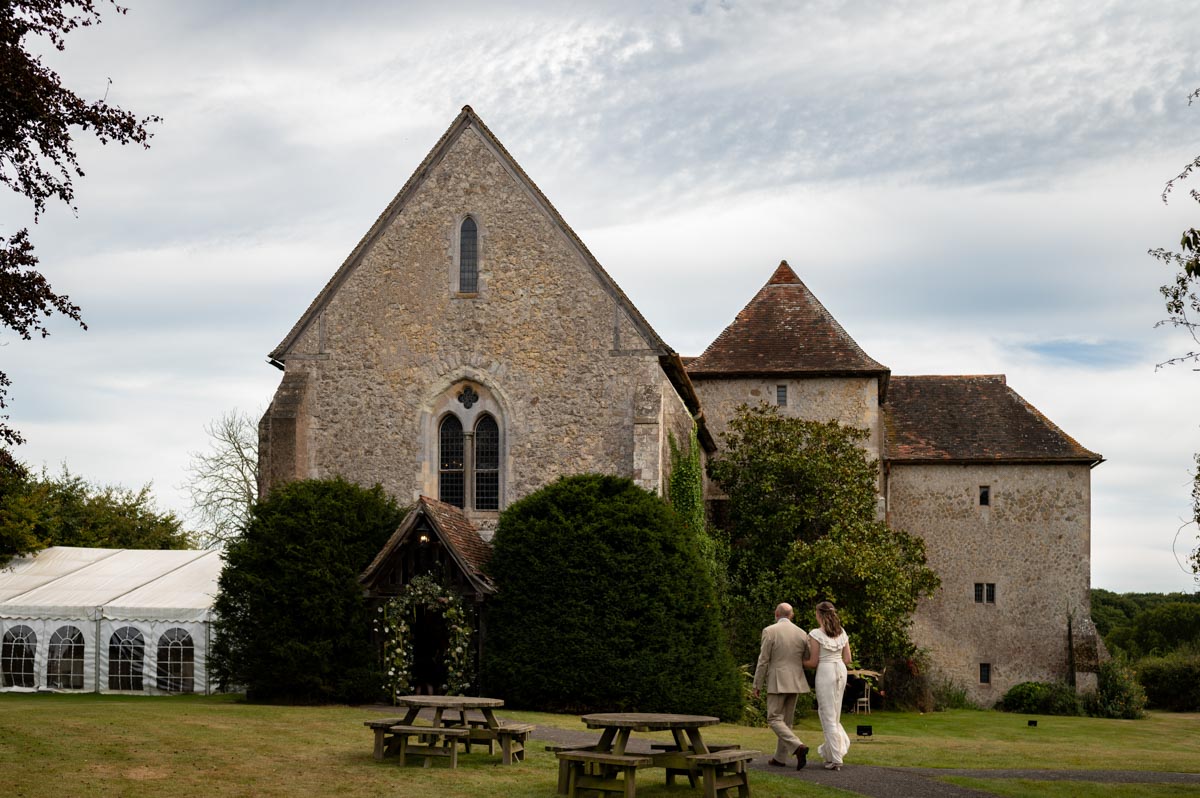 Bride and her dad walking into Bilsington Priory on her wedding day