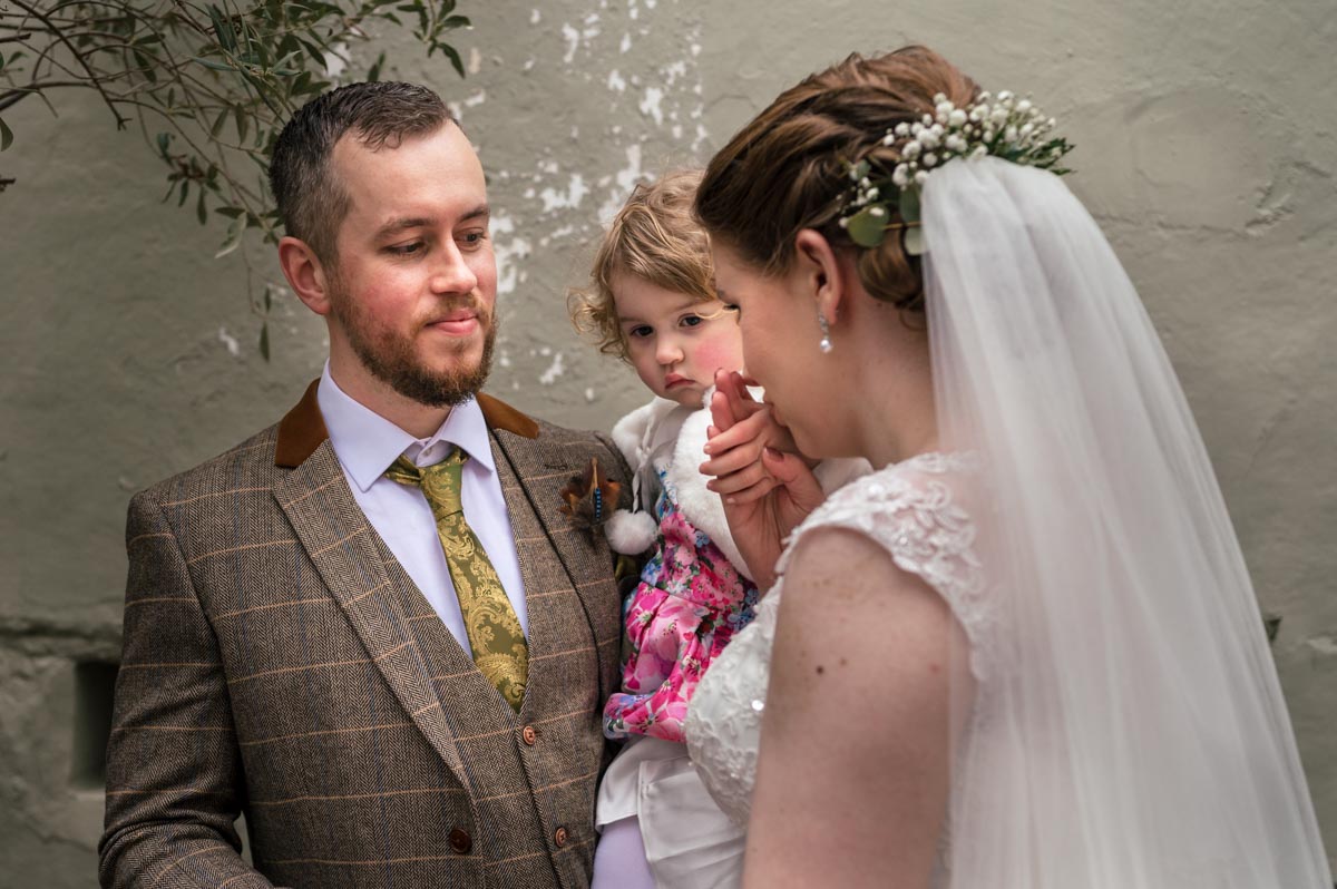 Laura and Jacob with theri daughter during the wedding ceremony at the secret garden in kent