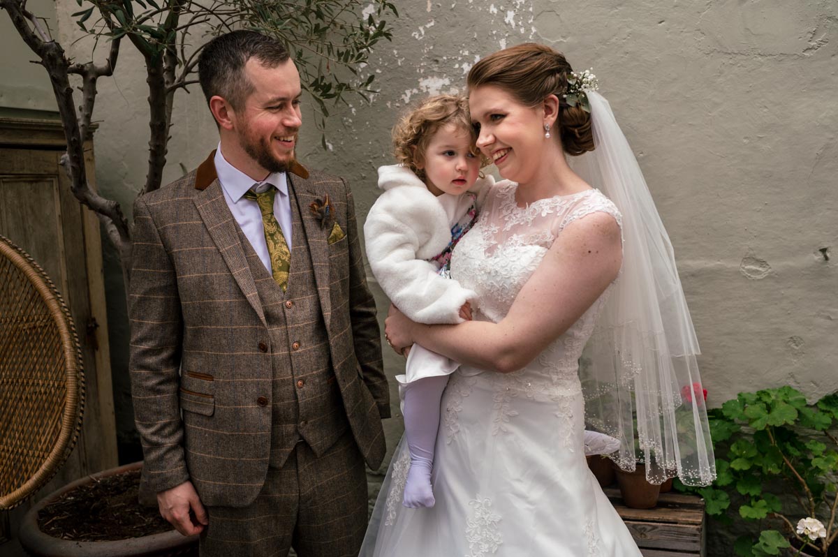 The secret garden wedding photography. Laura and Jacob with their daughter during their ceremony.