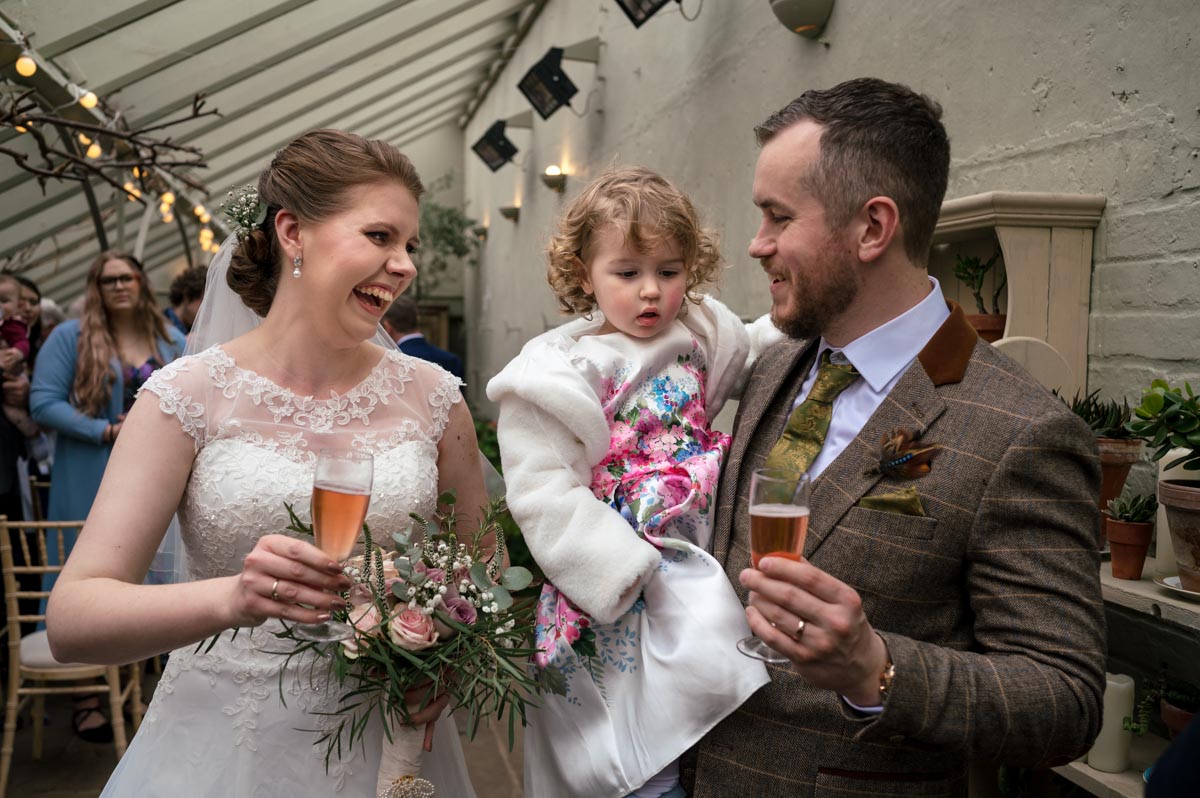 Photograph of Laura and Jacob drinking bubbles at their secret garden wedding in kent