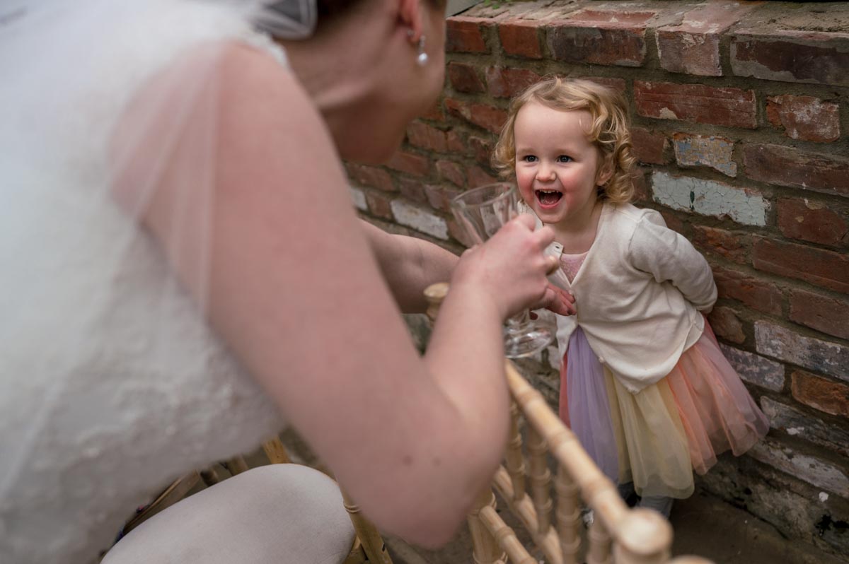 Bride and child share laugh at the secret agdren wedding in kent