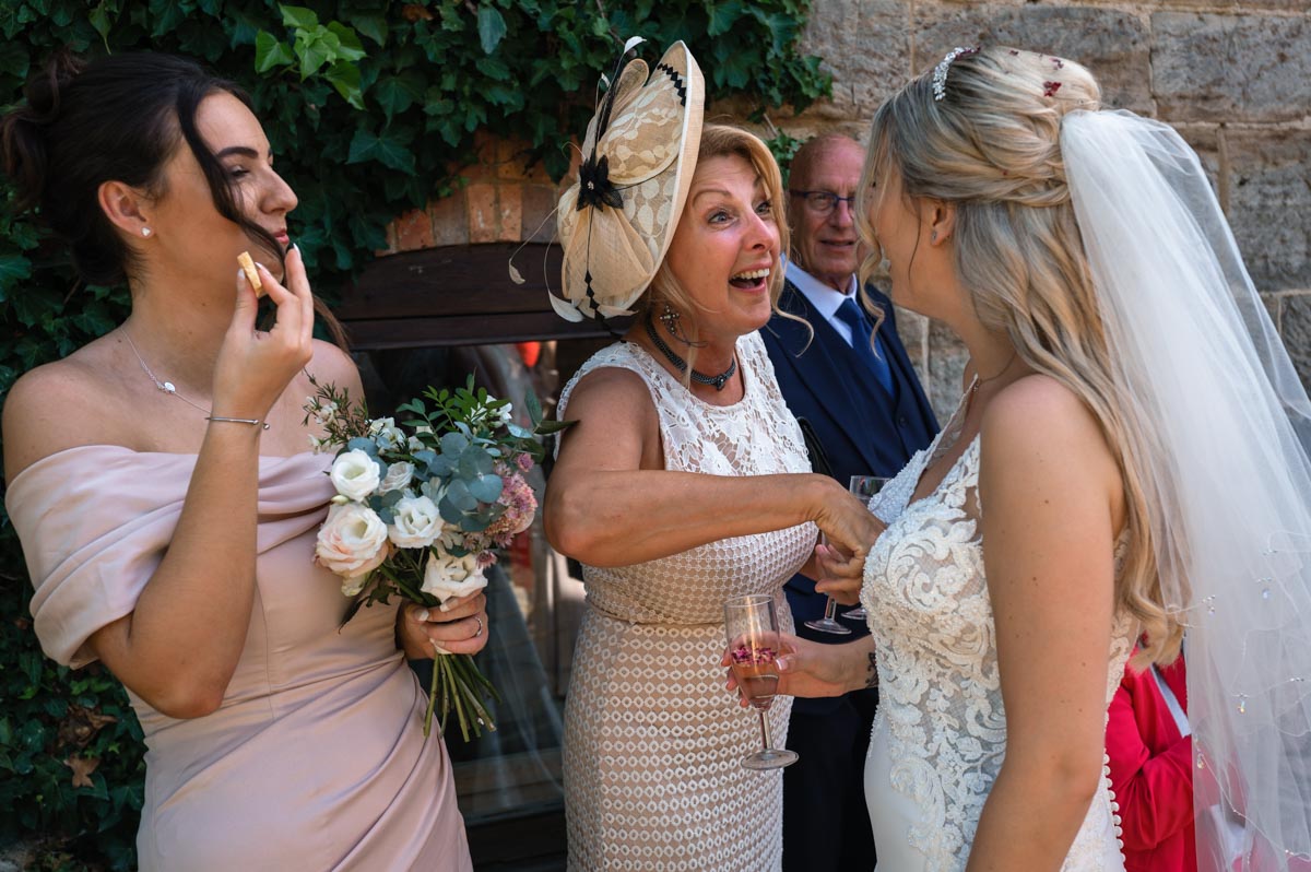 Guest retrieves confetti from Sarahs dress at her swallows oast wedding