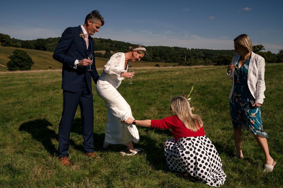 Outdoor wedding photography in Kent. Sarah's shoe gets stuck in the soft ground
