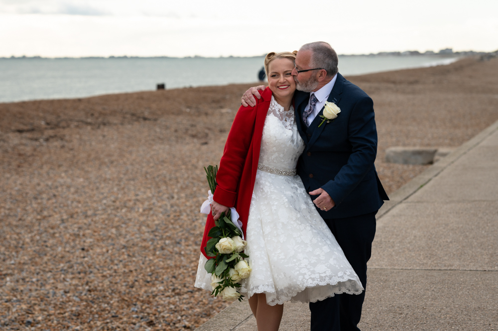 Bride and groom photographed at Sandgate beach after their small wedding in Folkestone, Kent.